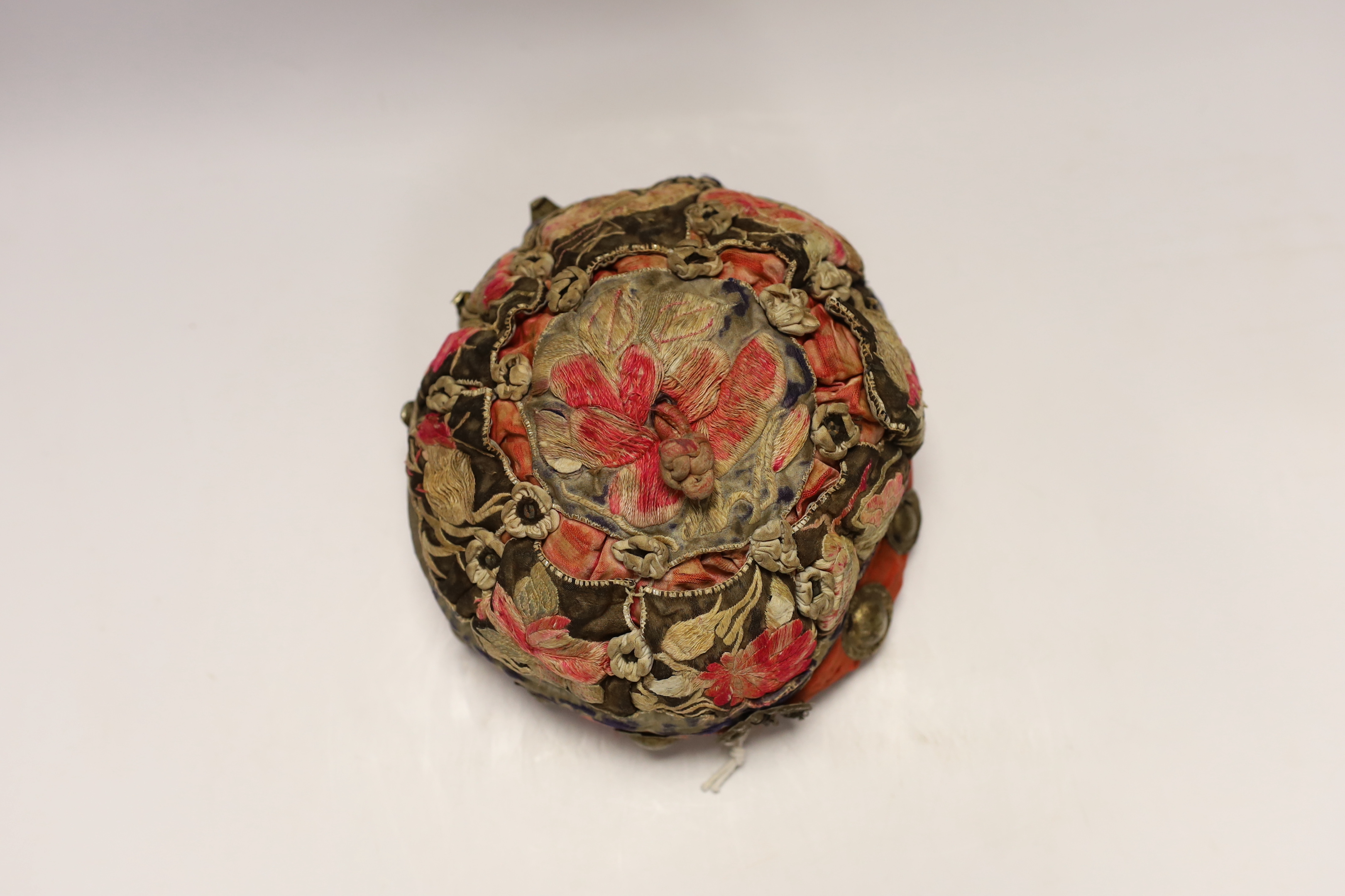 A Chinese metal mounted and embroidered skull cap